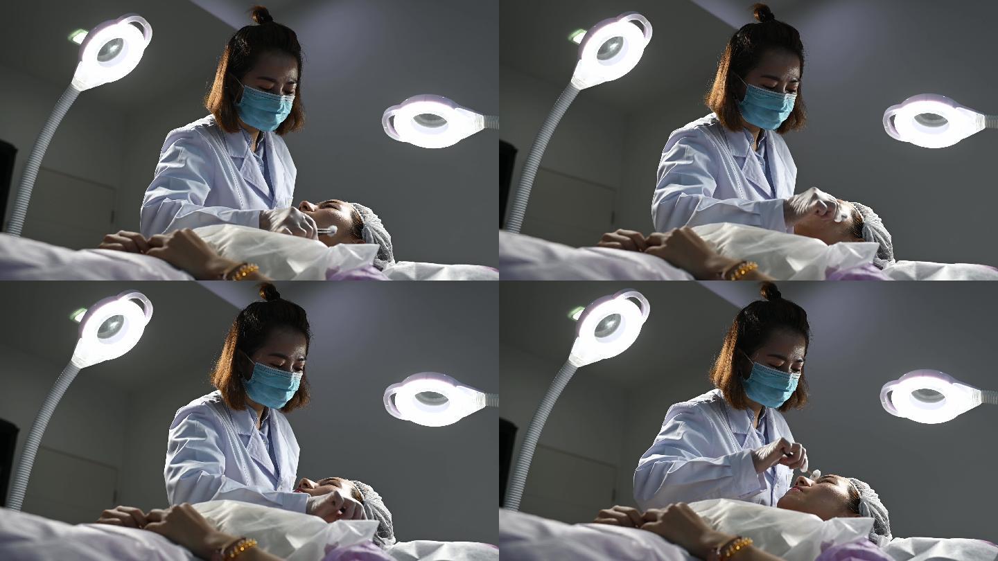 中国亚裔女护士在患者面部应用面部凝胶麻醉剂