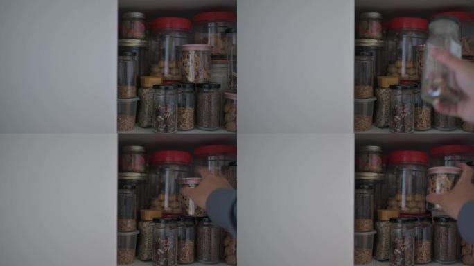 亚裔中国男性从厨房货架橱柜中取出食品瓶