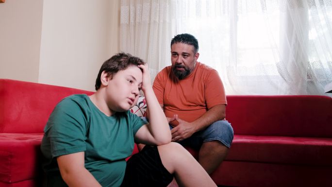 一个十几岁的男孩和他父亲谈话时感到心烦意乱。