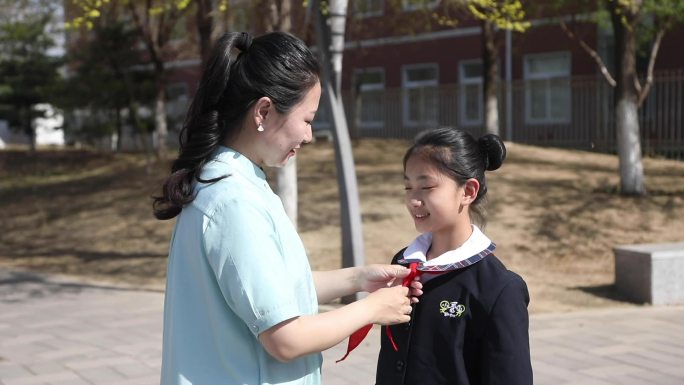 老师给学生系红领巾