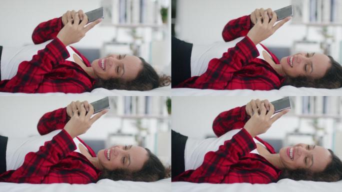 年轻女子在床上玩手机
