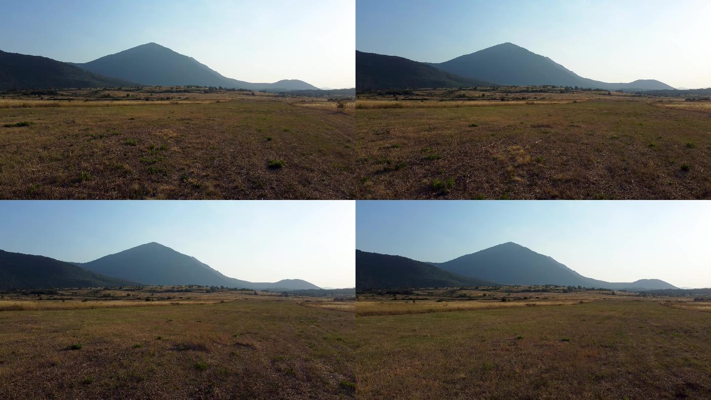 日落时分，飞越一片草地，飞向一座金字塔形的山，塞尔维亚东部的塔尼杰山