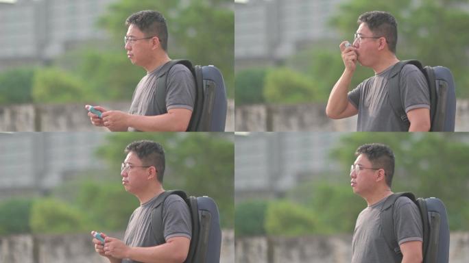 亚洲中国中年男子日落时在户外使用哮喘吸入器背着beg