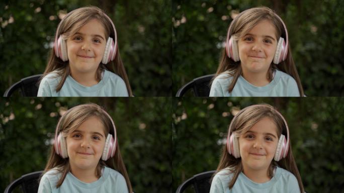 可爱的小女孩戴耳机听音乐肖像