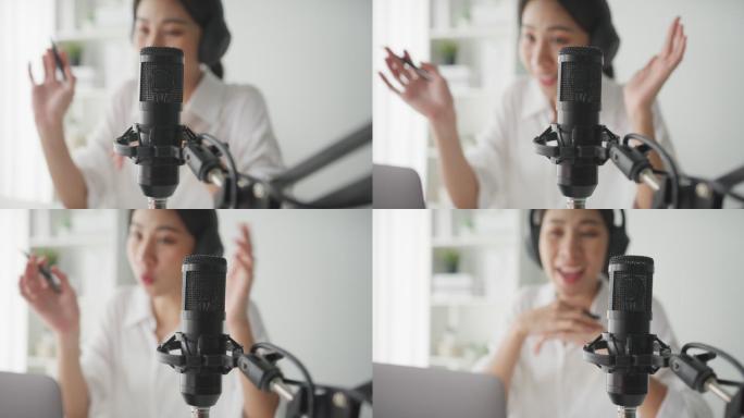 一位年轻的亚洲女性从家庭工作室用笔记本电脑录制播客的特写镜头。