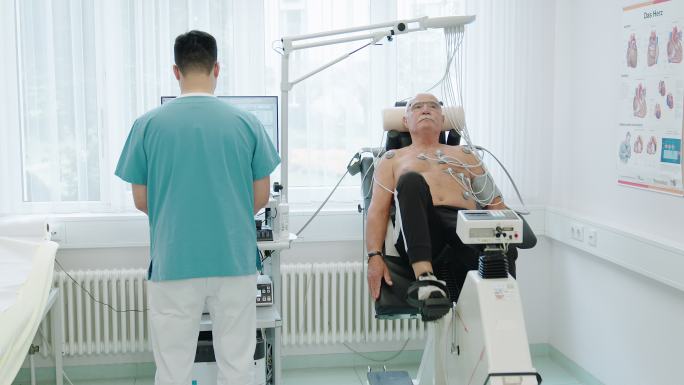 静态自行车上进行心脏压力测试的老年男性患者