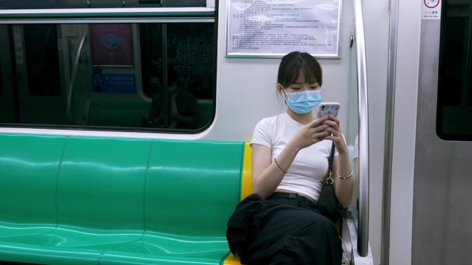 地铁上一个女孩玩手机