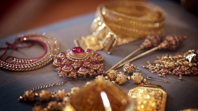 多利右侧相机，展示古代黄金珠宝和配件，以及传统泰国风格的宝石。