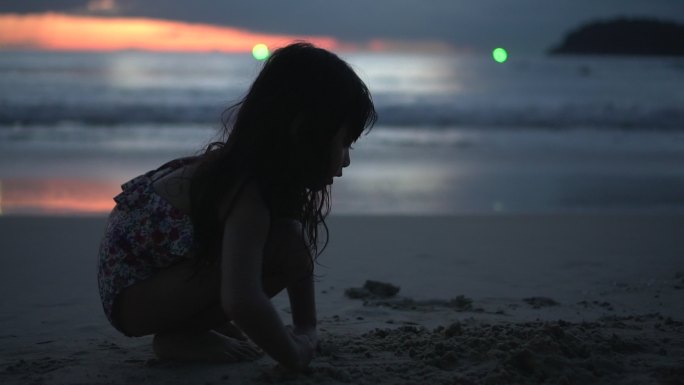 可爱的女孩在沙滩上玩沙子，玩得很开心
