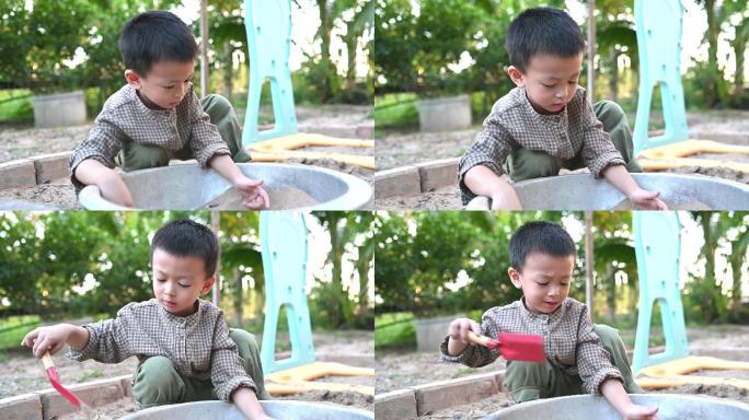 亚洲男孩在沙盒里玩沙子