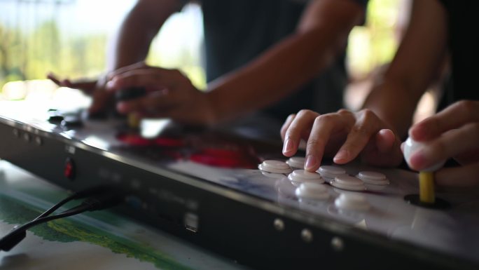 2名亚裔中国男性在周末社交聚会上玩复古风格的电子游戏