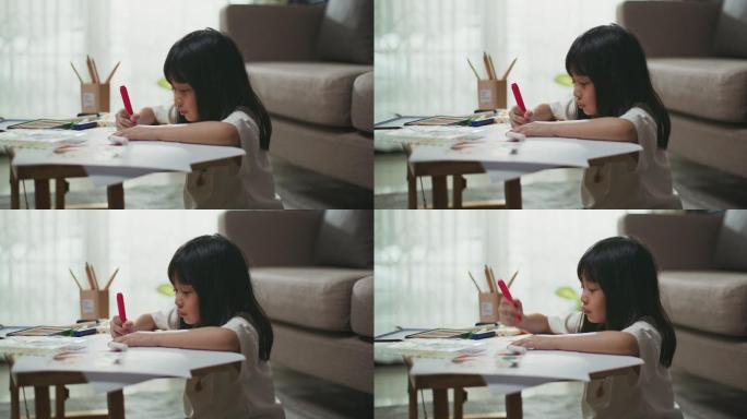 一个小女孩在客厅的桌子上选铅笔做作业