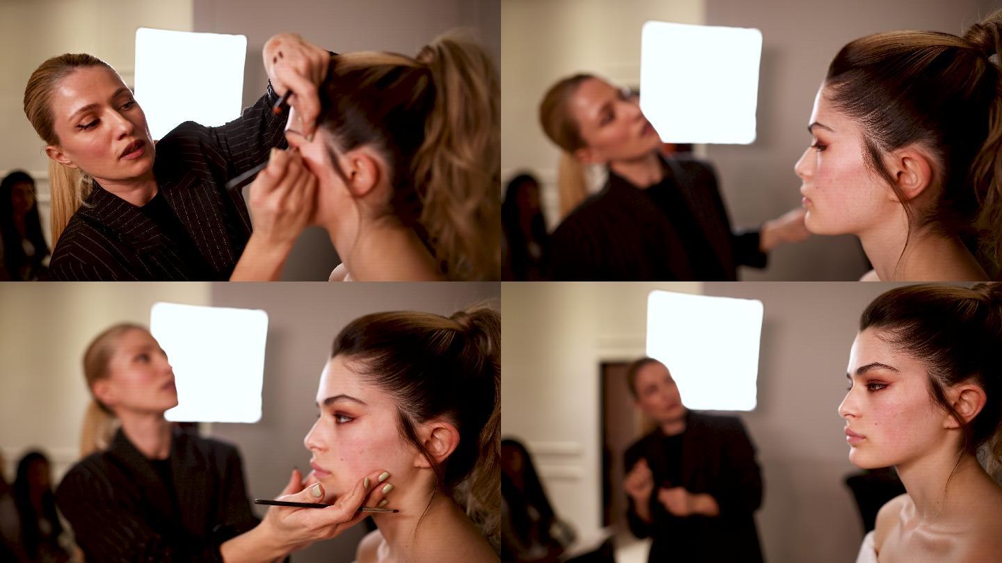 化妆师在演示中给女孩涂眼影