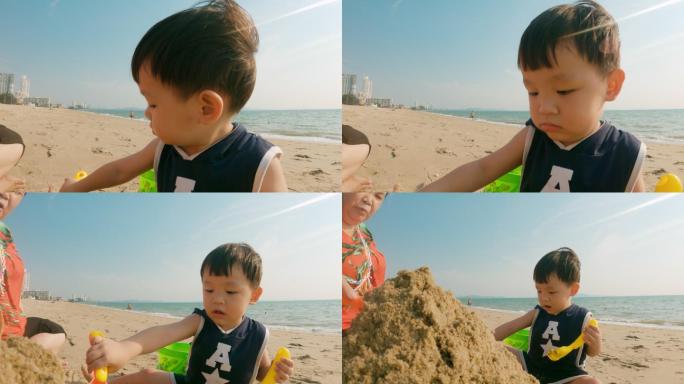可爱的男孩在沙滩上玩沙子，玩得很开心