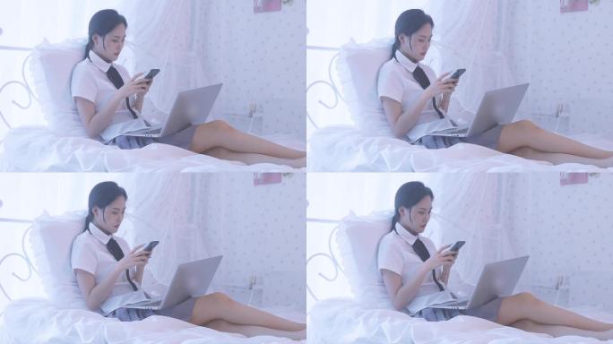 一名东方女性在卧室床上坐着玩手机