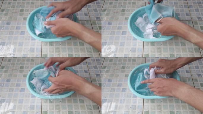 4K特写镜头。男人在塑料盆里洗手