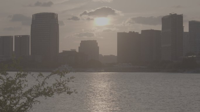 夕阳西下，轮船往往，江边的日落和城市交融