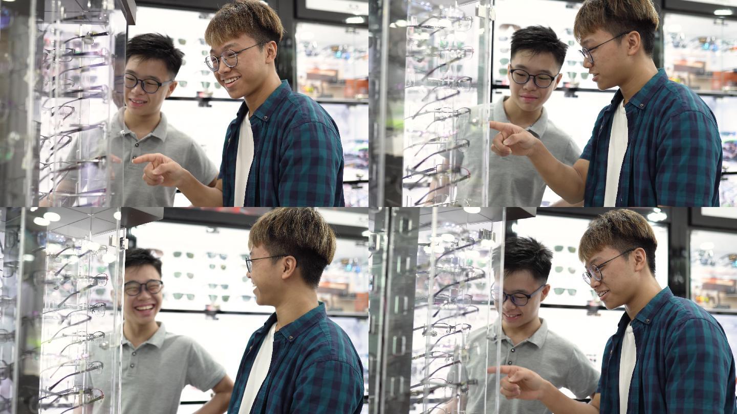 在眼镜店，两名亚裔中国少年在镜子前试眼镜