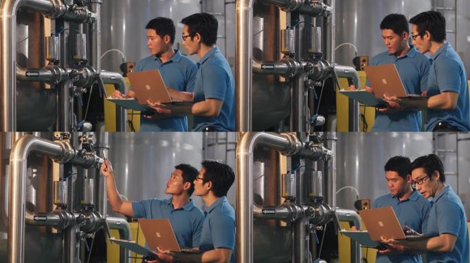 2名亚裔中国技师维护工程师记录水箱中的压力计读数瓶装水厂的日常质量控制在剪贴板上书写进度