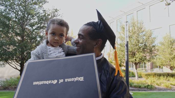 骄傲的祖父向孙女展示他的大学文凭
