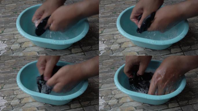 4K特写镜头。男人在塑料盆里洗手