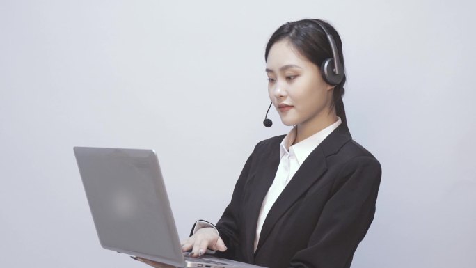 一位女性电话客服 在笔记本电脑前办公工作