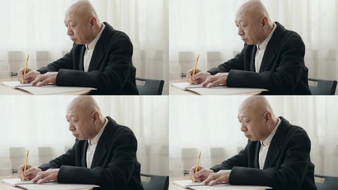 亚裔华裔老人在办公室写字