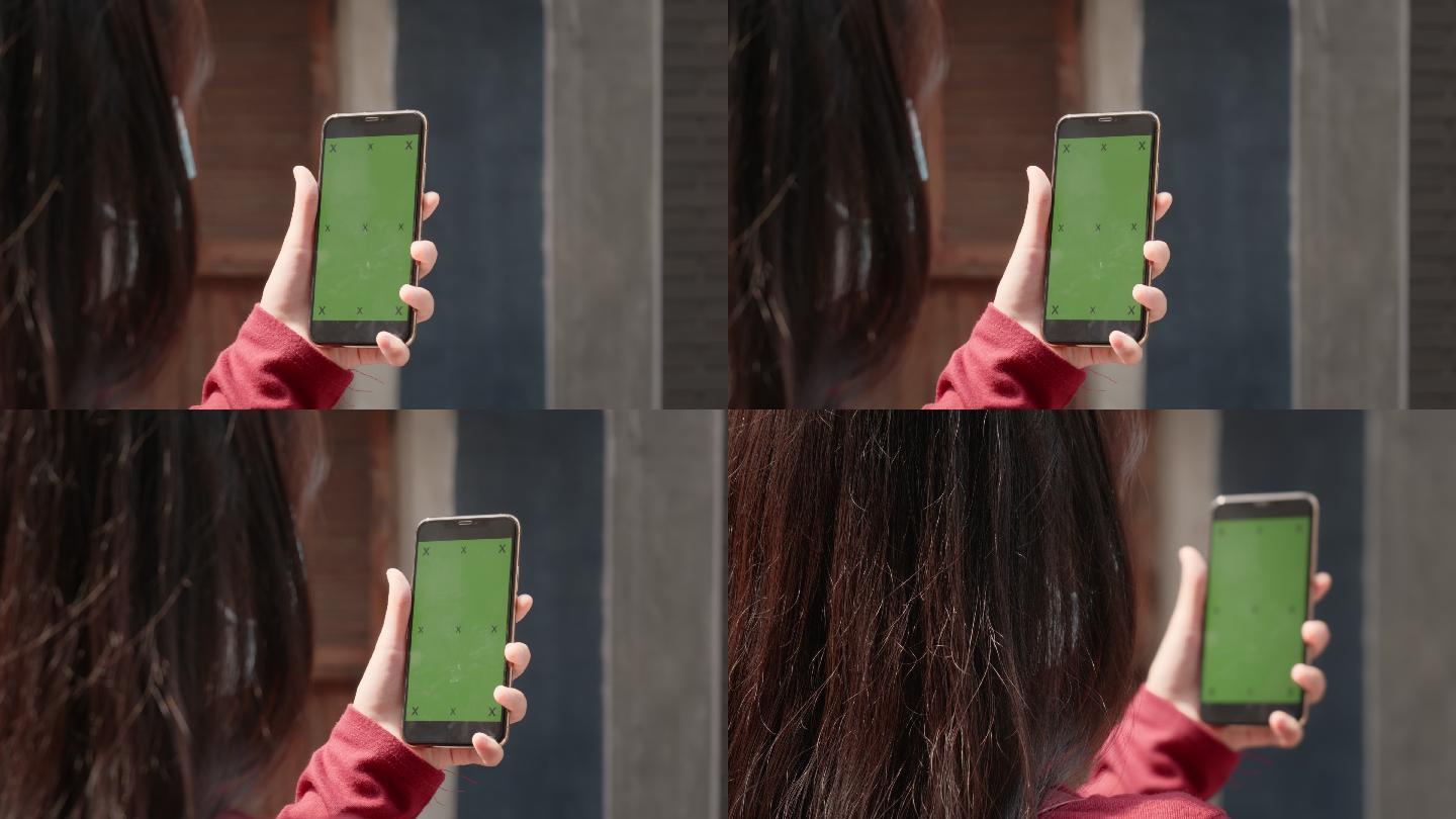 穿着休闲装的女士使用绿色屏幕的手机。