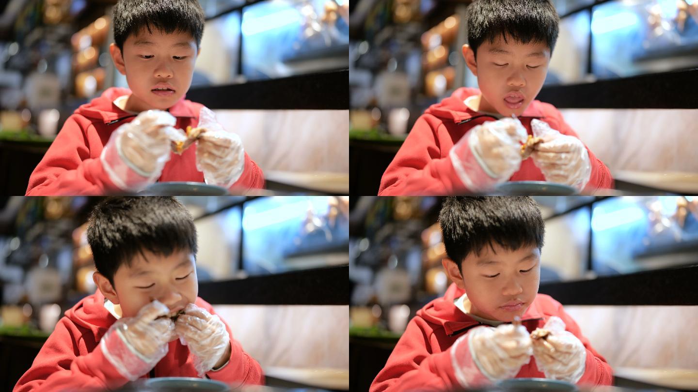 小男孩吃烤乳鸽认真吃肉小孩带透明套吃肉一