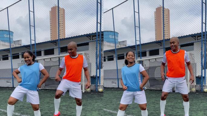 在运动场上，年轻男女足球运动员在社交媒体上舞动-手机拍摄