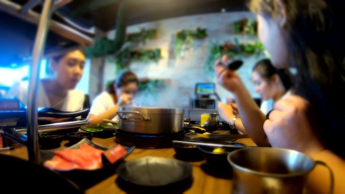 一群十几岁的亚洲人在台湾的购物中心吃着涮涮涮锅，这是都市人的生活方式