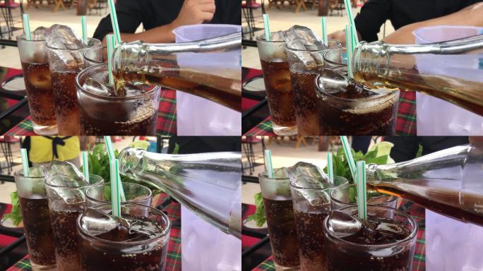 将可乐/可乐/苏打水倒入桌子上的玻璃杯中