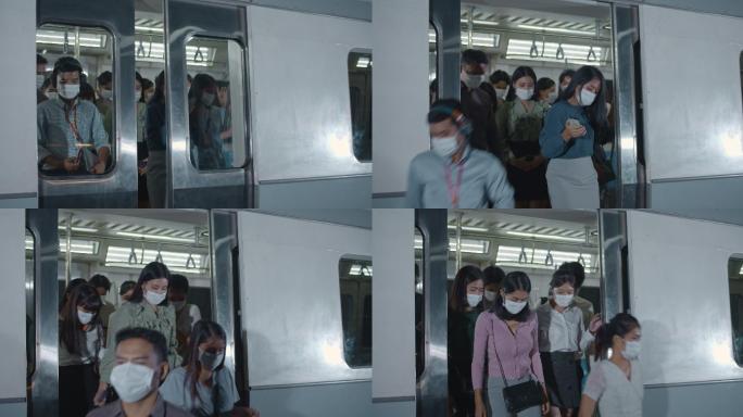 许多戴着防护面罩的乘客在高峰时间进出列车
