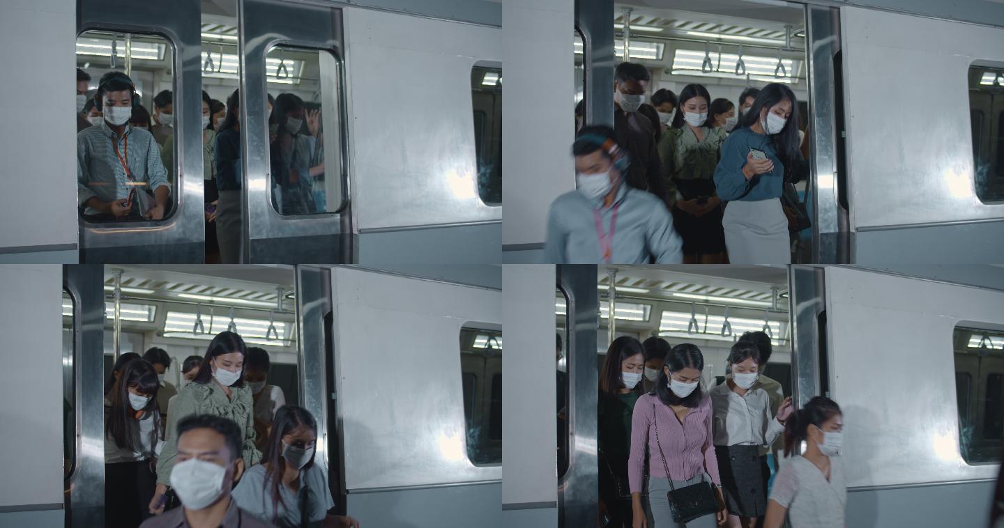 许多戴着防护面罩的乘客在高峰时间进出列车