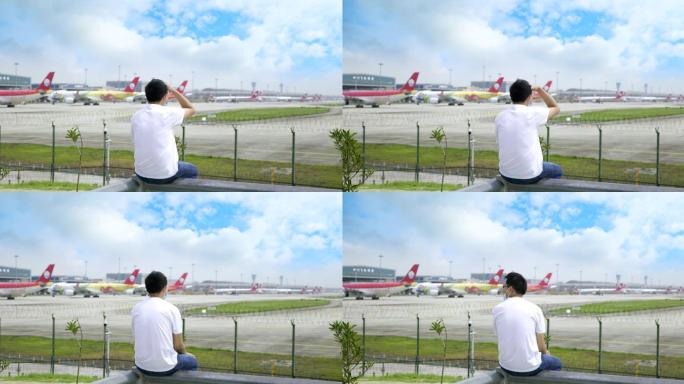 男子孤独惆怅地看机场内的飞机