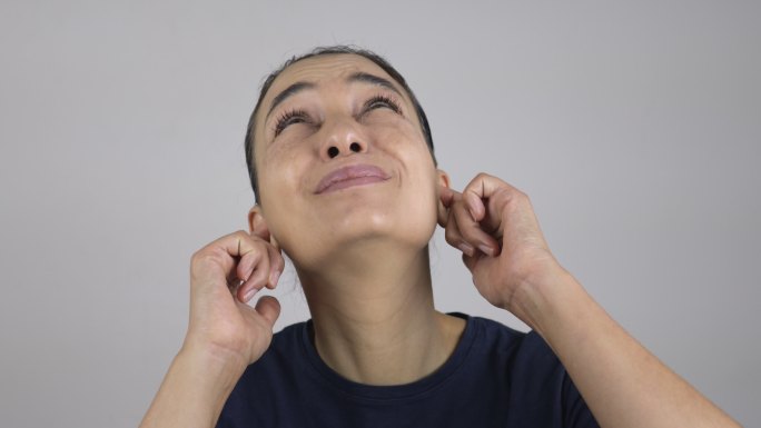 女人用手指捂住耳朵