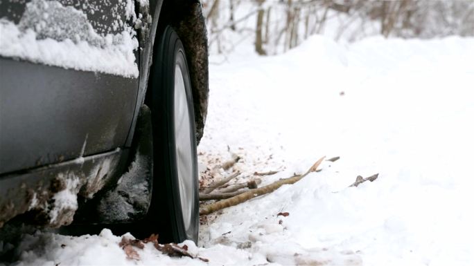 陷在雪地里的汽车的旋转车轮。