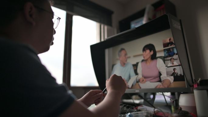 亚裔中国男性在家工作，使用台式PC视频电话会议商务会议