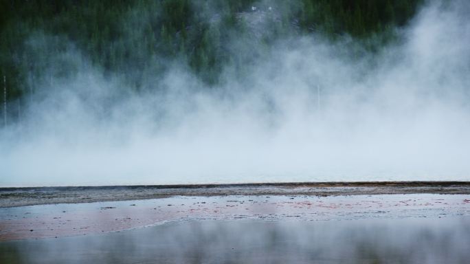 怀俄明州黄石国家公园的一片森林附近，大棱柱形温泉的热水冒着蒸汽