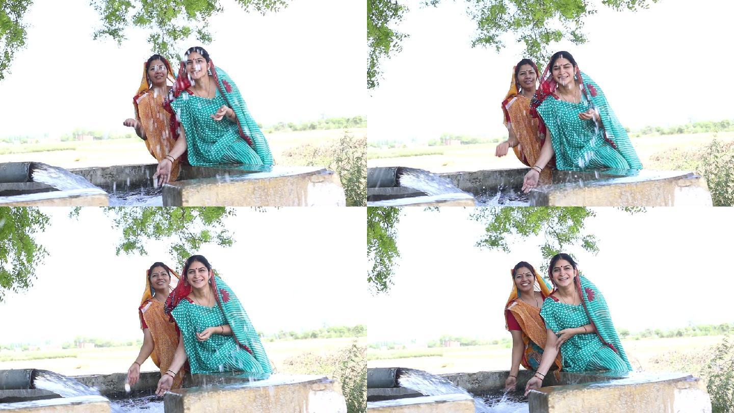 两个女人在田里泼水玩得很开心