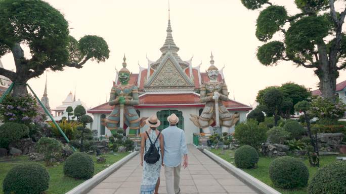 泰国曼谷阿伦寺，一对混血儿夫妇手持旅游地图，向游客们展示了他们在度假时的快乐之旅