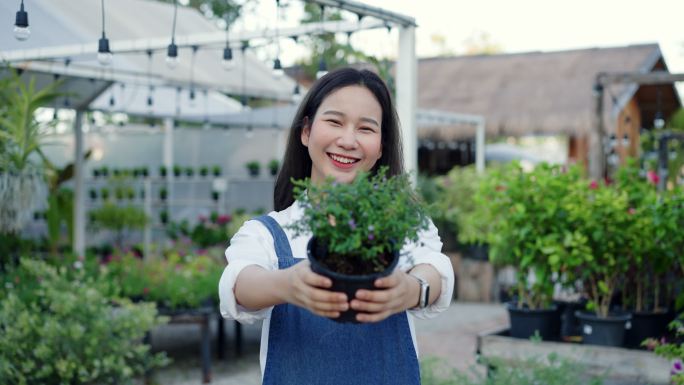 亚洲的小企业主微笑着。邀请人们进入商店