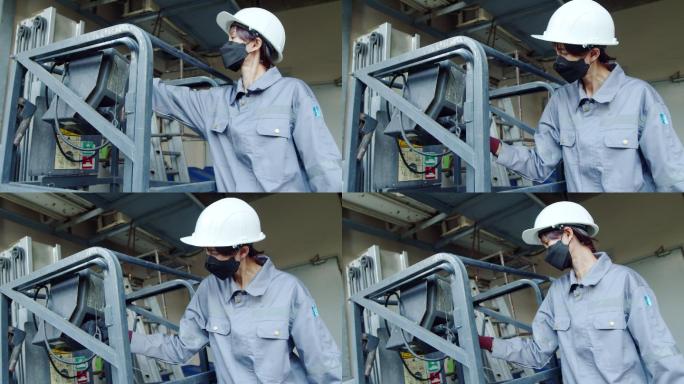 亚洲女技师检查员检查机器电梯牵引车。工程师女性触摸