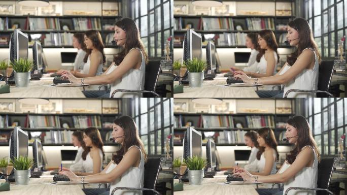4K微笑的女商人在使用电脑时戴着耳机