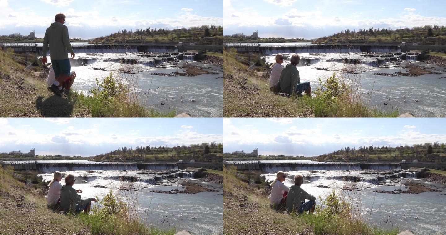 成年夫妇在河流和水电站大坝上方放松