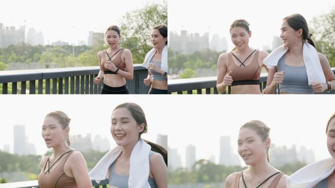 正面图：两位亚洲美丽的中年女性朋友穿着运动装，肌肉发达，早上一起在市中心附近的公园花园的人行桥上积极