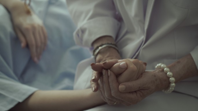 医生握住病人的手，鼓励病人，咨询病人。