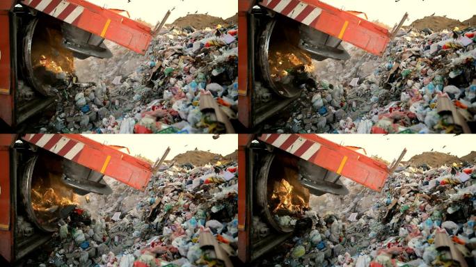 垃圾填埋场上的垃圾车正在倾倒垃圾。垃圾运输车