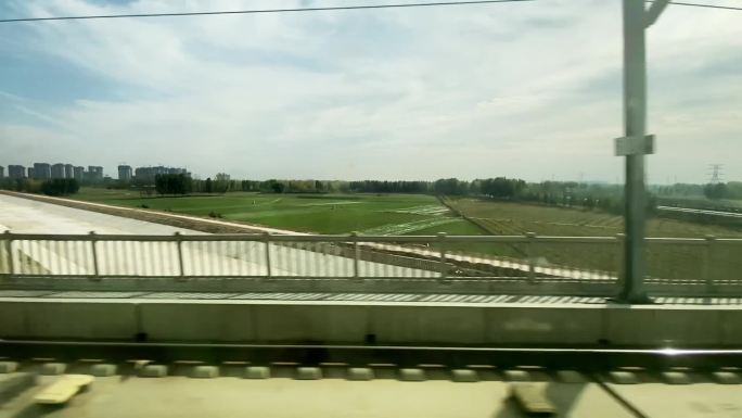 在火车上望着窗外，经过市郊的公路和农场运河