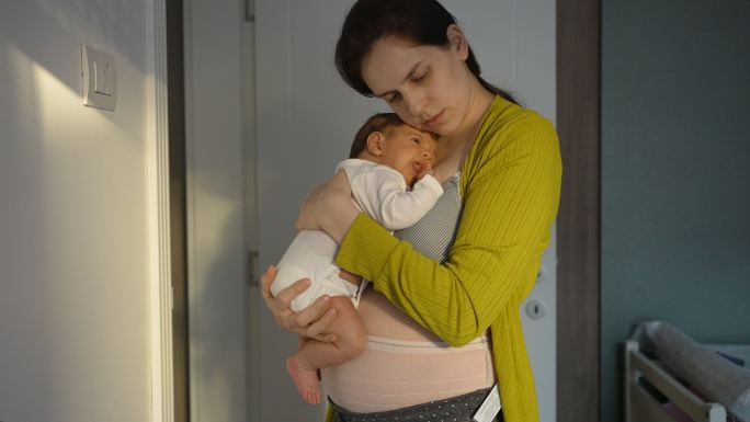 妈妈穿着产后内衣抱着新生女婴